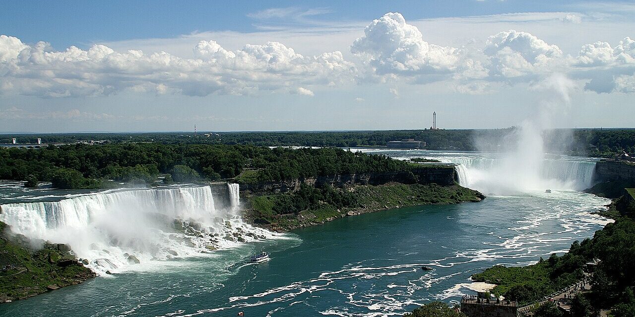 Captivating view of the popular Niagara Falls with lush green vegetation in surroundings.