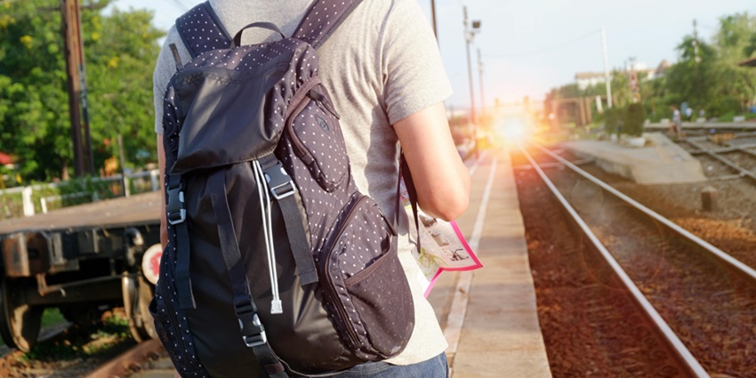 Person in Grey Top With Backpack Waiting for Train - pack all the essentials for your trip