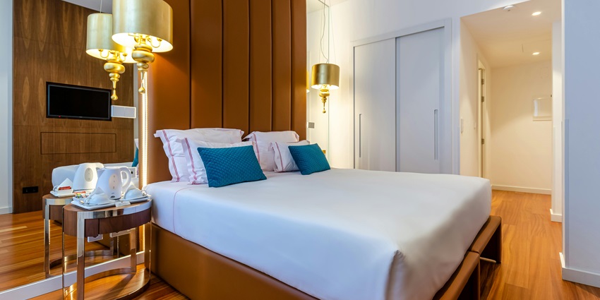 A modern century hotel room with wooden interiors and soft ascent lighting turned on.