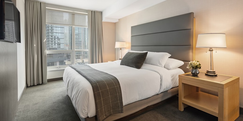 A view of a hotel room with a white-linen bed that provides a comfortable stay