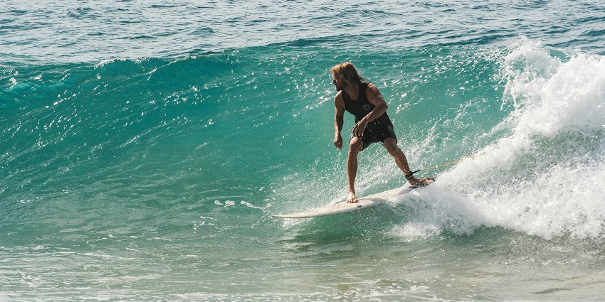 Keep your adrenaline pumping as you surf through the turquoise waters on a beach.