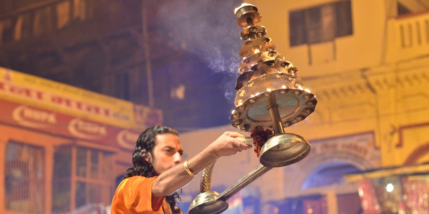An aarti puja in progress, with devotees and vibrant lights - a must do in Baijnath Temple