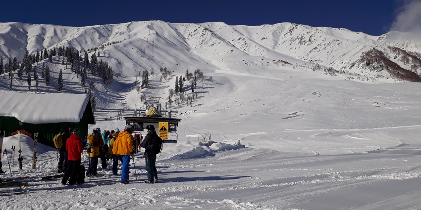 A picture of a snow-covered mountain in the Himalayas with people enjoying adventure sports