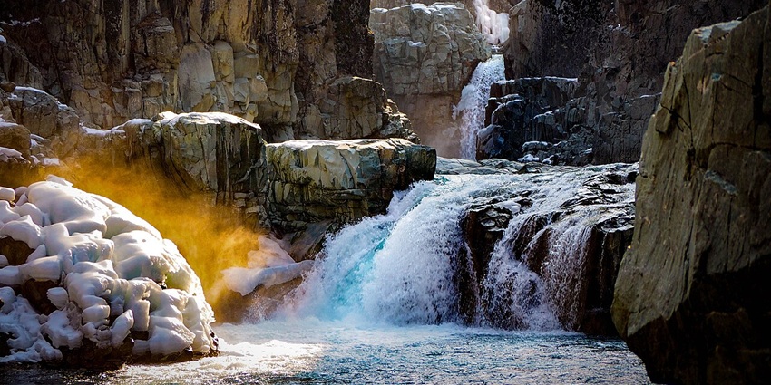 Aharbal Waterfall cascading through rocky gorge surrounded by pine-covered cliffs–places to visit in kashmir in september