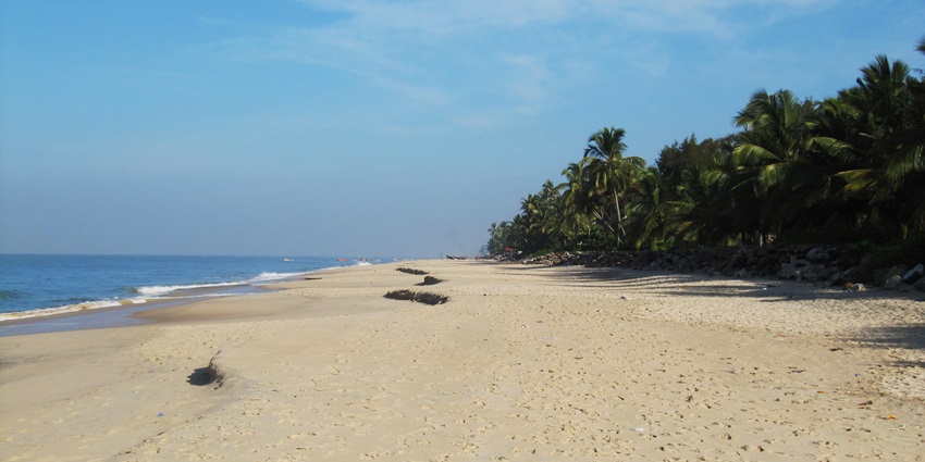 A mesmerising view of the Alappuzha Beach featuring blue waters and golden sands.