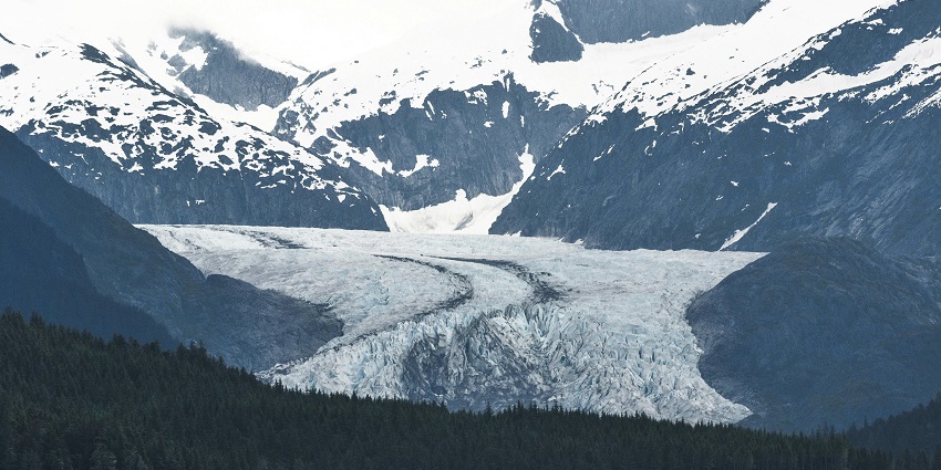 A captivating view of snow-clad mountain peaks and lush green trees in Alaska, USA