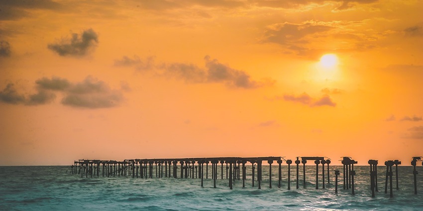 Beautiful sunset view at Alleppey Beach with golden skies, calm waves - beaches in Kerala