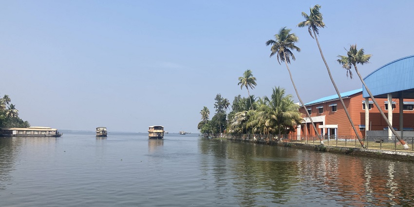 A view of the Alleppey backwaters in Kerala, with its houseboats and palm trees