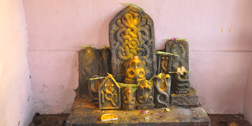 A picture of a Nagaraja idol decorated with garlands and tilak, at a temple in Kerala