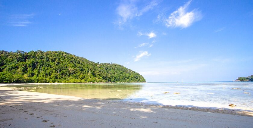 The view of an island with lush green forests along the azure waters of Andaman sea.