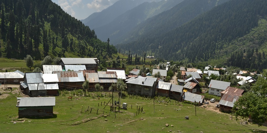 An aerial view of village settlements in the scenic Aru Valley with views of mountains in the background