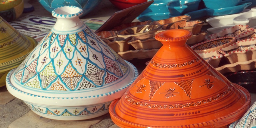 Colourful traditional pottery wares adorn a sunlit market stall in charming Sidi Bousaid.