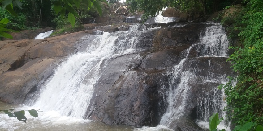 Jaw-dropping view of Aruvikkuzhi Waterfalls in Alappuzha encircled by lush green meadows.