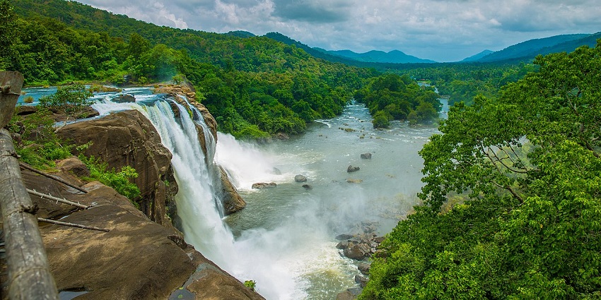 A breathtaking view of the Athirapally Waterfalls in Kerala with forest in the background
