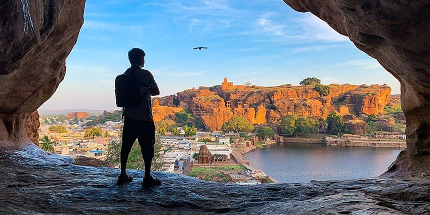 Man enjoying views from the entrance of a cave in the Badami Cave System