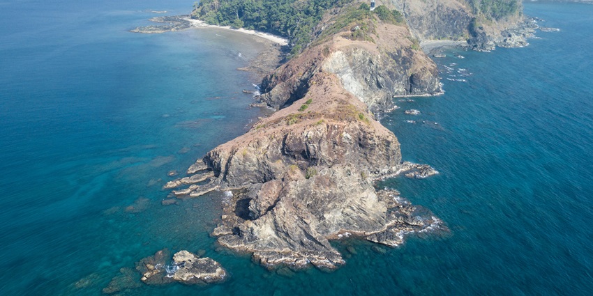 An island in the middle of the clear blue sea. The view looks splendid and breathtaking.