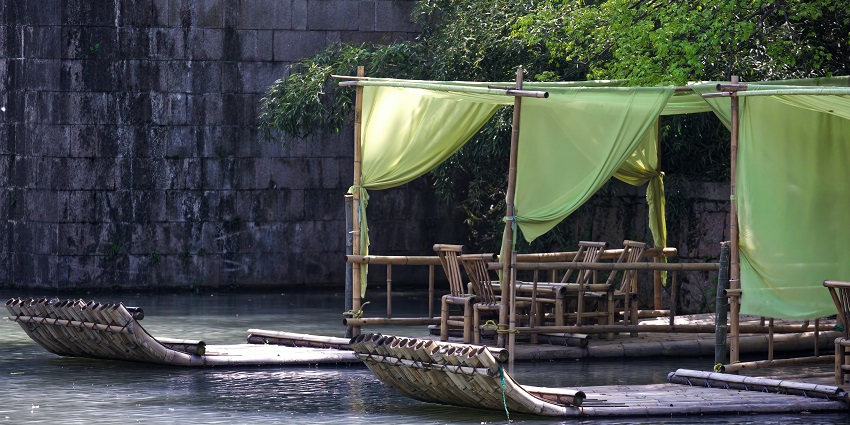A view of a bamboo raft on a body of water, which is one of the best activities in Kerala.