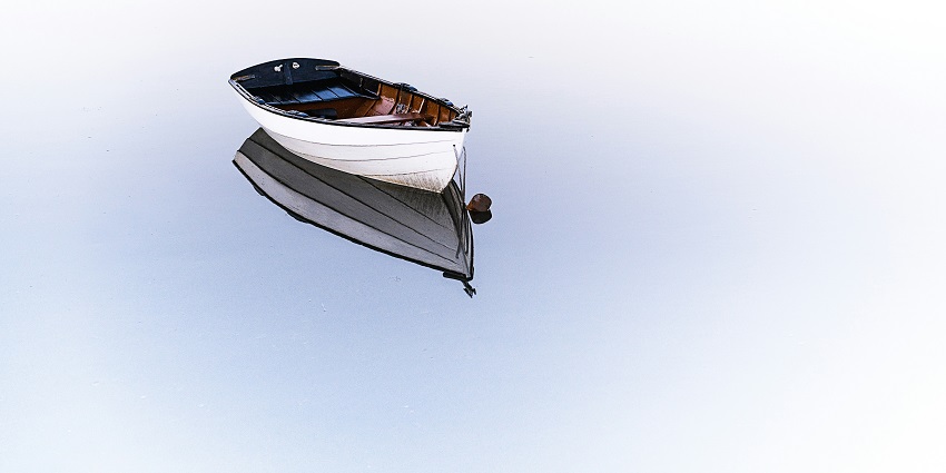 A mesmerising view of a white boat on a body of water with clear water during the day.