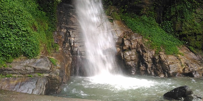A waterfall with rocks around its base