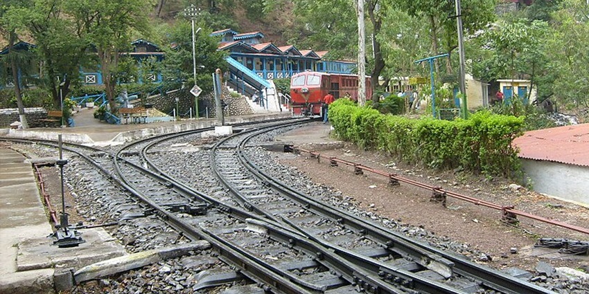 A picture of railway tracks with a train approaching on one of them