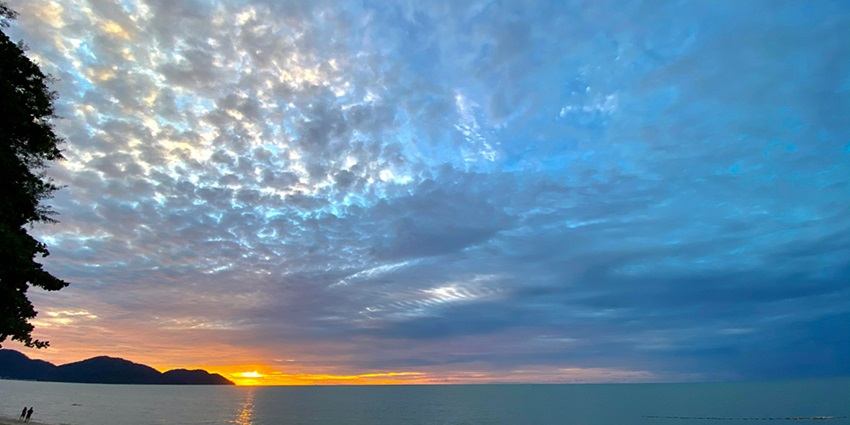 Batu Ferringhi Beach: picturesque sandy shore with clear waters and vibrant sunset views.