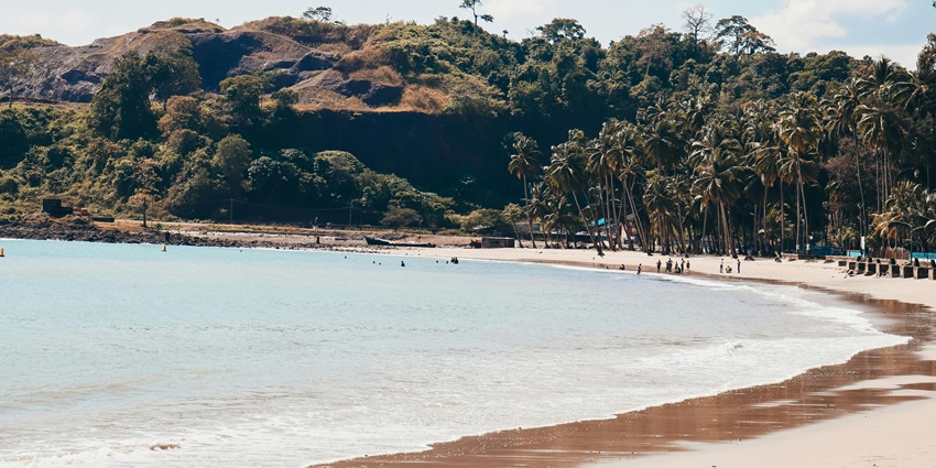 The view of sea water washing sandy beach on a sunny day under a beautiful blue sky