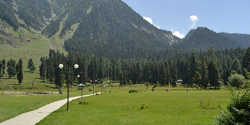 Scenic view of Betaab Valley, Kashmir with lush meadows, river, and surrounding forested hills