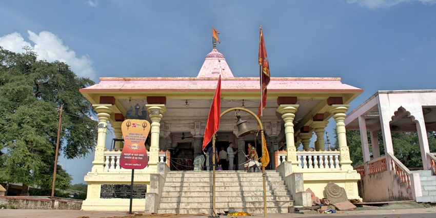 A frontal view of a traditional Hindu temple in Jammu, surrounded by greenery