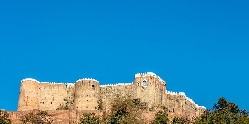 istoric Bhim Garh Fort in Reasi, showcasing impressive architecture atop a hill.