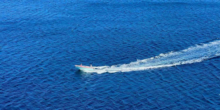 A scenic view of a speed boat in the middle of ocean in St Vincent and the Grenadines