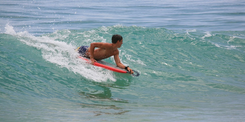 A man enjoying bodyboarding in the crystal clear and serene waters at the sea