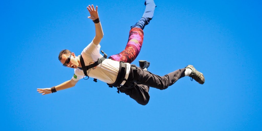 The image depicts a man engaging in an exciting activity while suspended in mid-air.