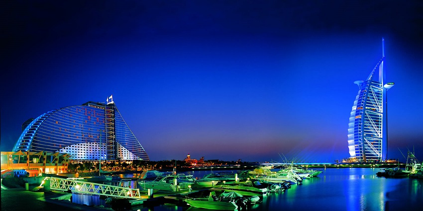 Stunning night view of Burj Al Arab and Jumeirah Beach Hotel with yachts in the marina