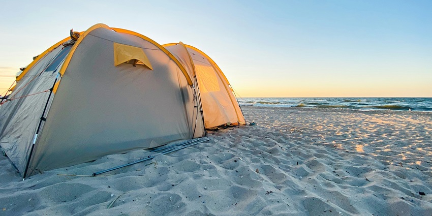 Camping on the beach and relaxing under the stars with tents set up on pristine sandy shores.