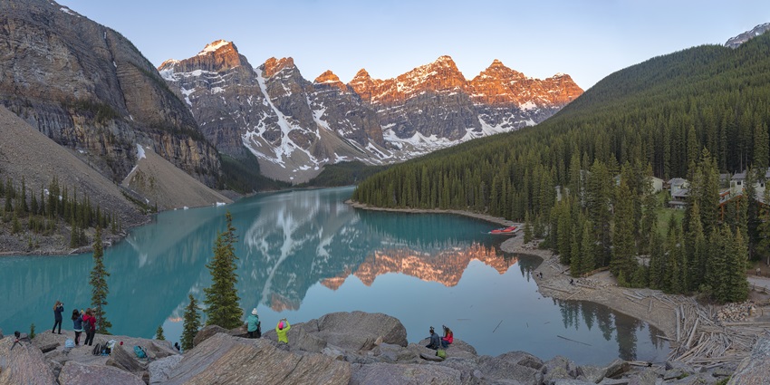 A picture of Moraine Lake, Alberta offering scenic views of the tall mountains and lush greenery nearby