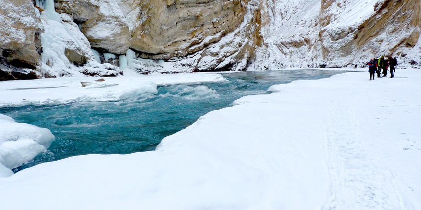 A frozen waterfall and trekkers on Chadar trek