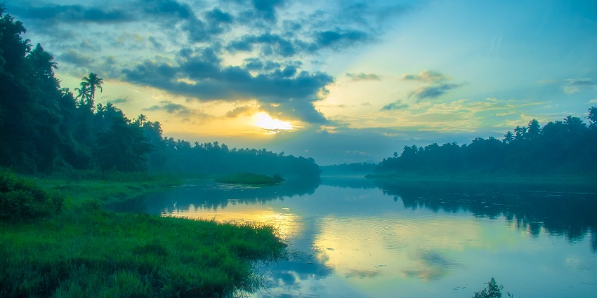 Witness the serene sunrise at the beautiful Chalakudy River, near Athirapally in Kerala.