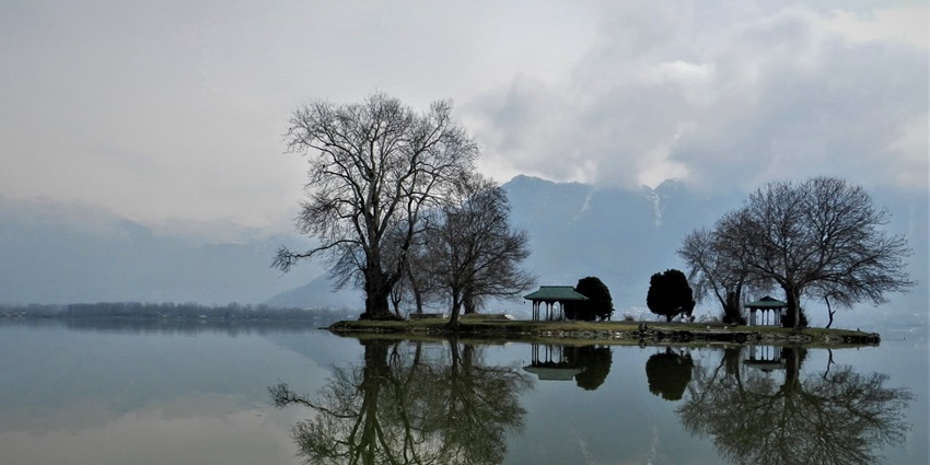 A mesmerising view of Char Chinar with a scenic backdrop of cloudy sky and mountains