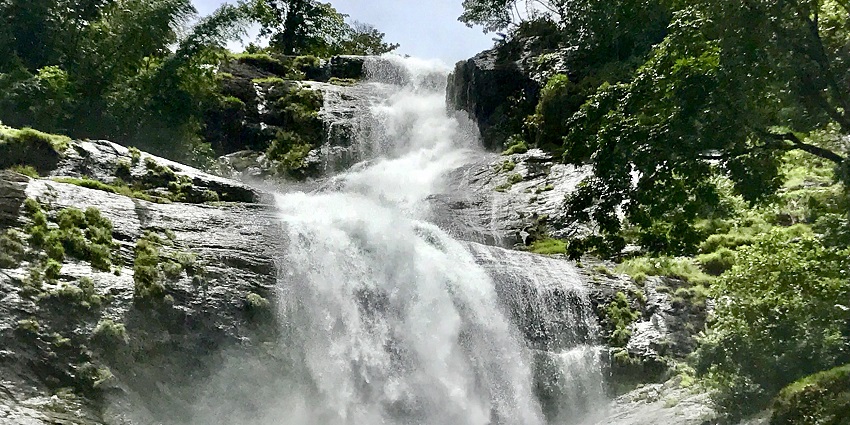 A mesmerising view of a fall in Kerala with lush green surroundings during the day.