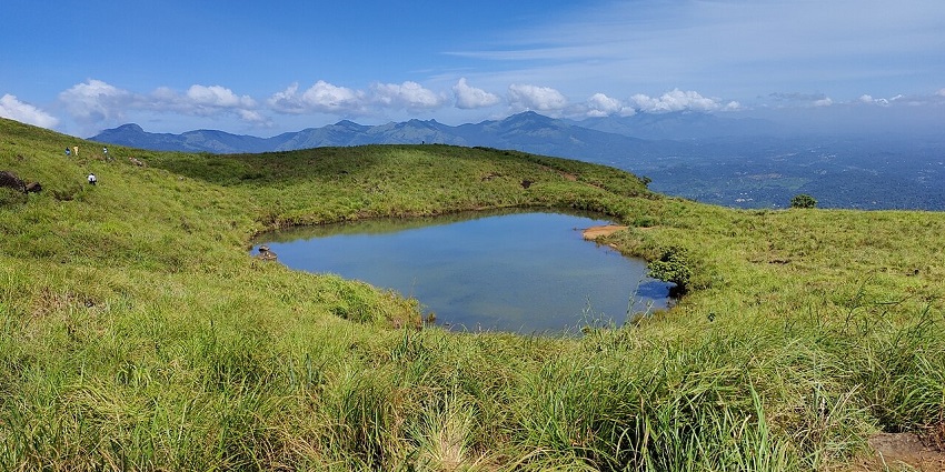 Explore the sparkling heart-shaped lake of Chembra Peak near Kanthanpara Waterfalls.