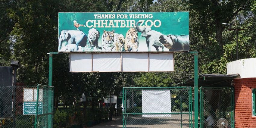 View of the entrance gate with a sign board of Chhatbir Zoo in Chandigarh.