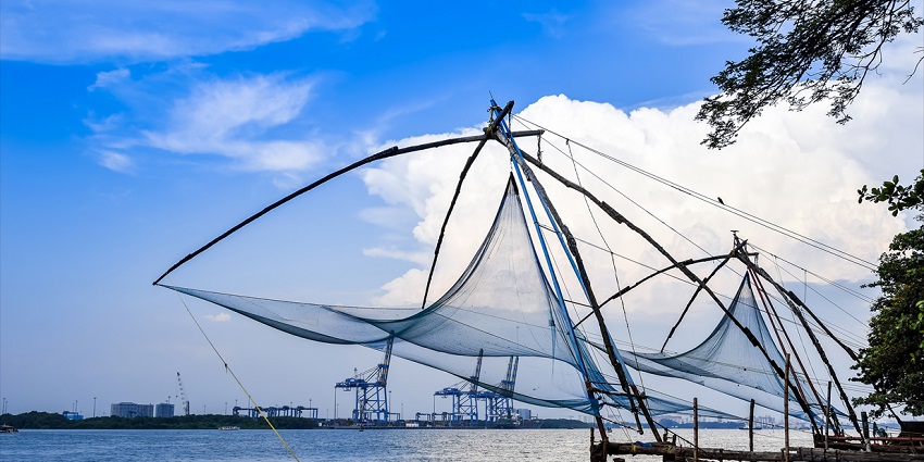 Chinese Fishing Nets with blue sky and white clouds in background - theme parks in Kerala