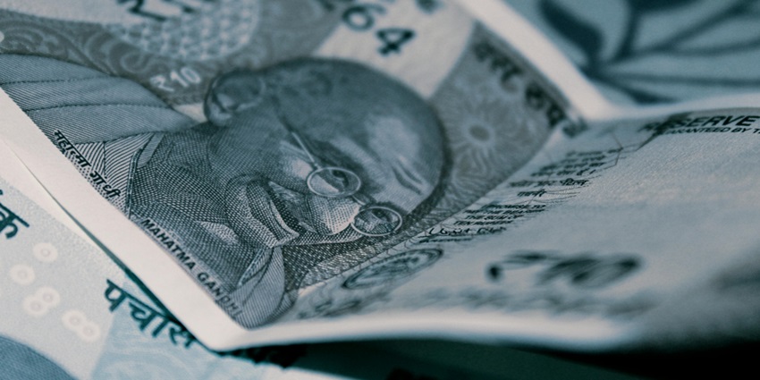a closeup of an India rupee note on a table.