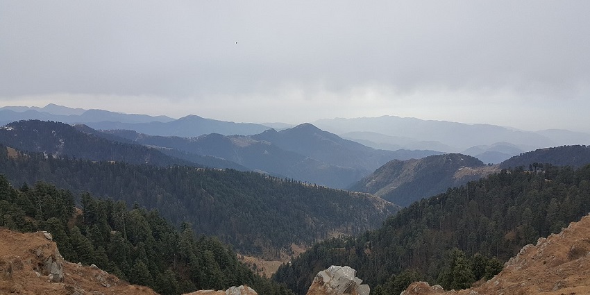 Scenic view of Dainkund Peak in Dalhousie with lush greenery and clear blue skies.