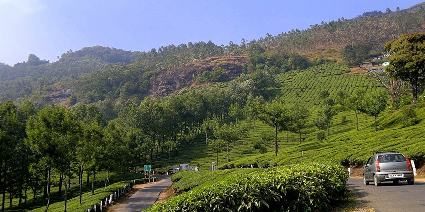 Devikulam, Munnar: Tranquil lake surrounded by lush green hills and misty ambiance.