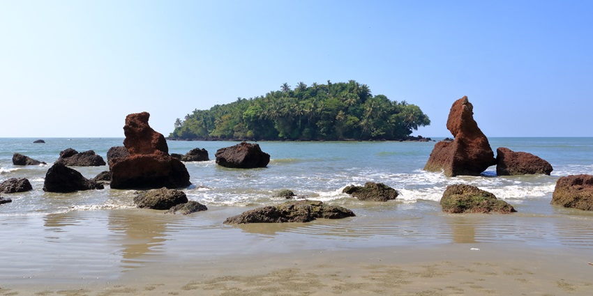 People walking at the Dharmadam Island Beach during the evening along the soothing shores