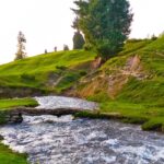 A stream going through the green meadows, one of the best places to visit in Doodhpathri.