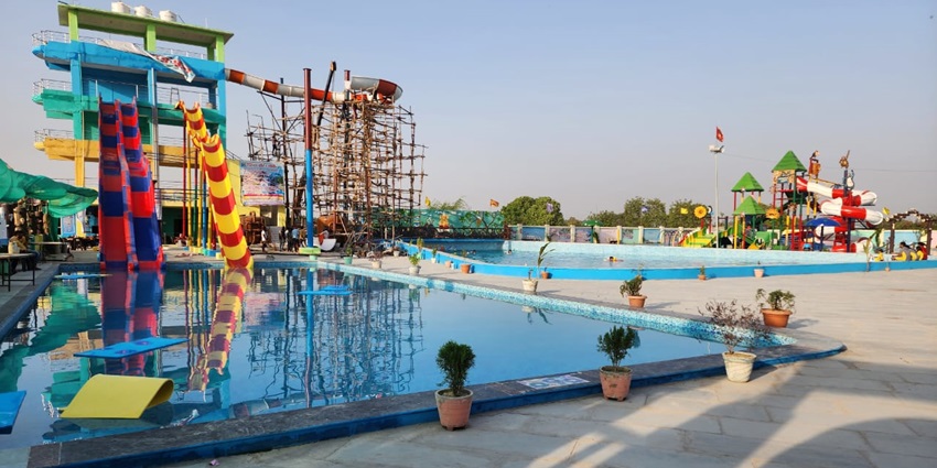 Colorful water slides, a large pool, and children enjoying playful rides at ernakulam waterparks