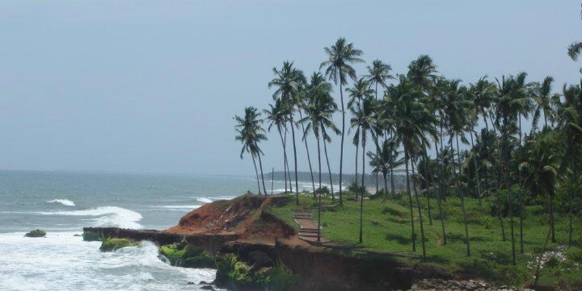 A beautiful scenery of Edava Beach with lush greenery at the nearby cliff & clear skies