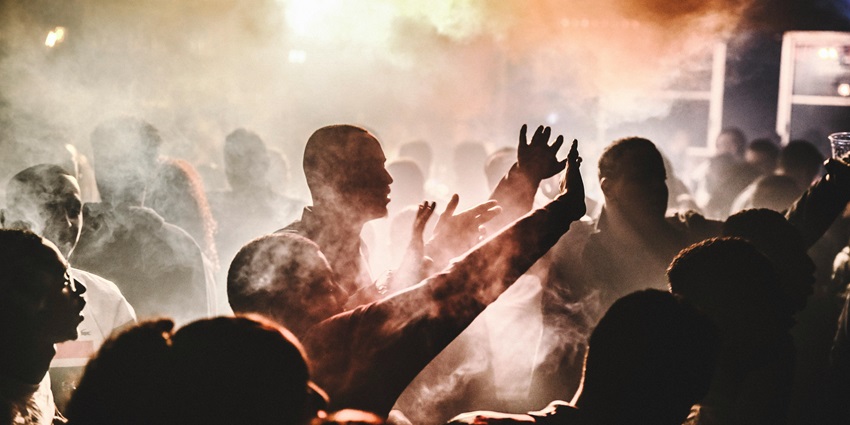Silhouettes of people raising hands in celebration against sunset sky—-kerala nightlife